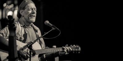 Man playing guitar and singing into microphone