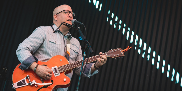Man playing guitar and singing into microphone